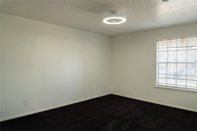 unfurnished room featuring baseboards and a textured ceiling