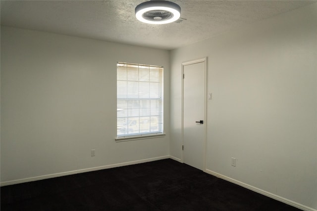 spare room featuring visible vents, baseboards, and a textured ceiling