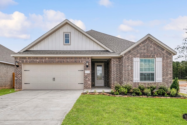 view of front of house with driveway, roof with shingles, an attached garage, a front yard, and brick siding