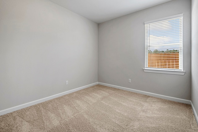 carpeted spare room featuring baseboards