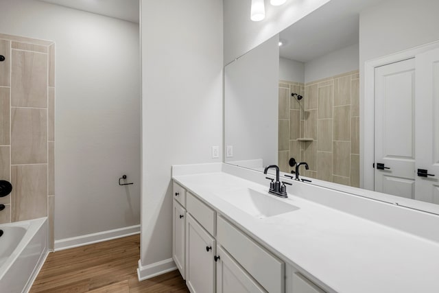 full bath with shower / bathtub combination, baseboards, wood finished floors, and vanity