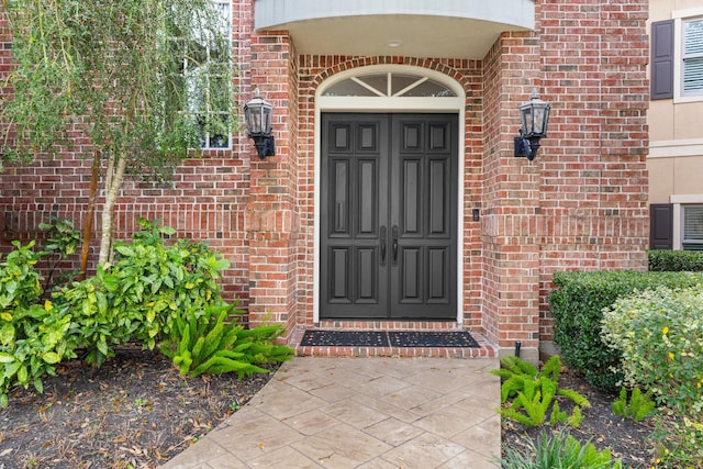 doorway to property featuring brick siding