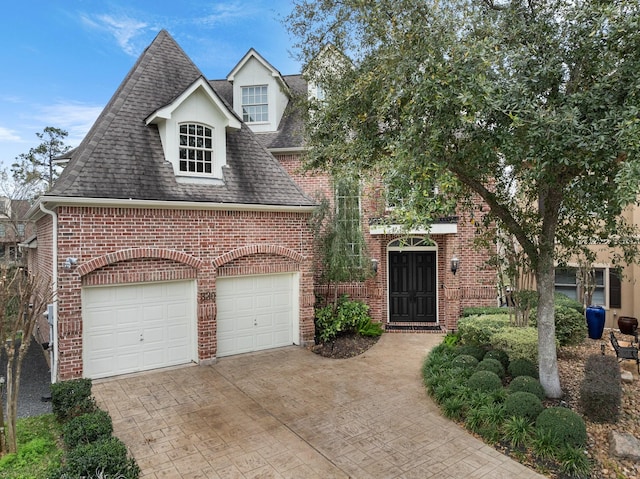 view of front of home with brick siding, driveway, a shingled roof, and a garage