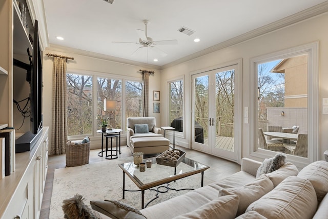 interior space featuring visible vents, light wood-type flooring, ceiling fan, and ornamental molding