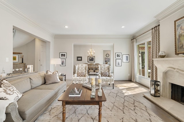 living area featuring crown molding, a chandelier, a premium fireplace, recessed lighting, and wood finished floors