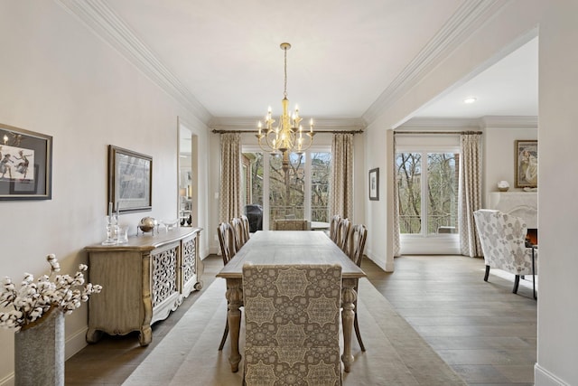 dining area with baseboards, an inviting chandelier, wood finished floors, and ornamental molding