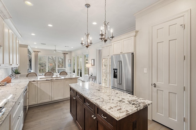 kitchen with crown molding, dark brown cabinetry, a chandelier, recessed lighting, and stainless steel appliances