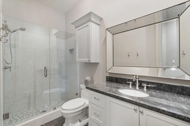 bathroom featuring a shower stall, toilet, and vanity