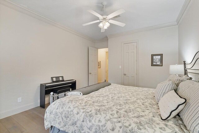 bedroom featuring crown molding, wood finished floors, baseboards, and ceiling fan