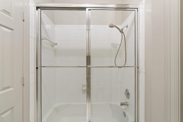 bathroom with bath / shower combo with glass door