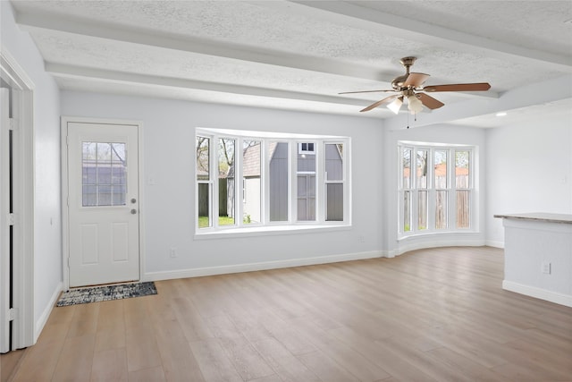 foyer with baseboards, light wood-style flooring, a textured ceiling, and ceiling fan