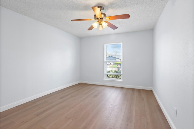 unfurnished room with light wood finished floors, a textured ceiling, a ceiling fan, and baseboards