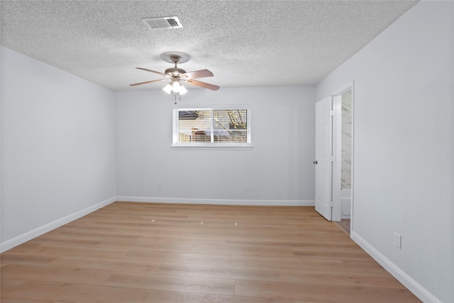 unfurnished room featuring visible vents, baseboards, ceiling fan, light wood-style flooring, and a textured ceiling