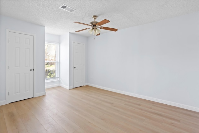 spare room with visible vents, baseboards, a ceiling fan, and light wood finished floors