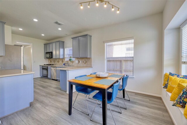 dining space with light wood-style flooring, baseboards, and a healthy amount of sunlight