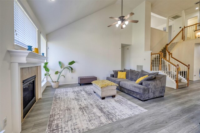 living area featuring visible vents, stairway, wood finished floors, and a tile fireplace