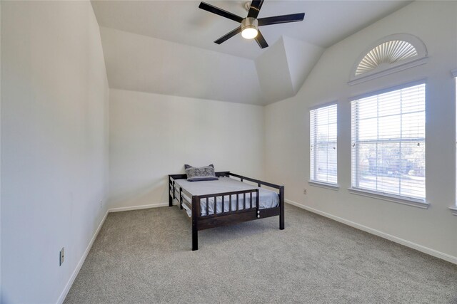 carpeted bedroom with lofted ceiling, baseboards, and ceiling fan