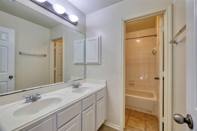 full bath with bathtub / shower combination, tile patterned floors, double vanity, and a sink