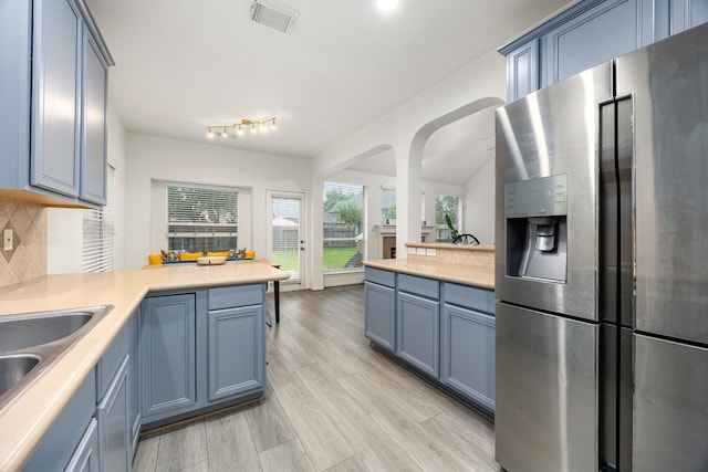 17614 Wind Mist Ln, Cypress, TX 77433 - kitchen featuring stainless steel fridge with ice dispenser, a peninsula, backsplash, light wood-style flooring, and light countertops