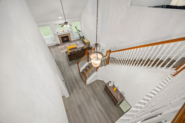 17614 Wind Mist Ln, Cypress, TX 77433 - stairs featuring wood finished floors, a tiled fireplace, and ceiling fan