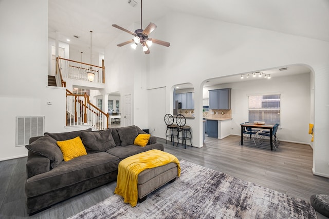 17614 Wind Mist Ln, Cypress, TX 77433 - living area featuring arched walkways, stairs, a ceiling fan, wood finished floors, and baseboards