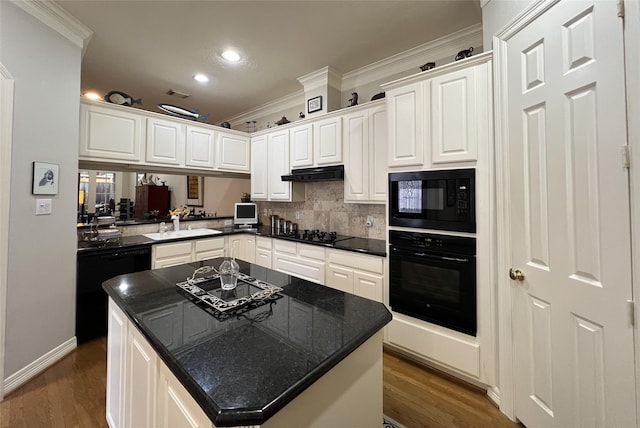 kitchen featuring dark countertops, crown molding, under cabinet range hood, black appliances, and dark wood-style flooring