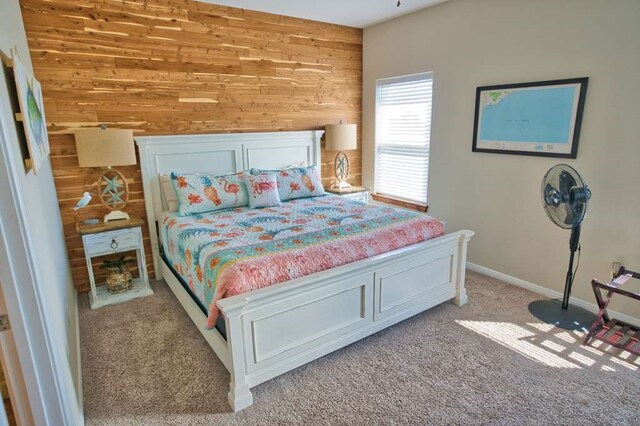 carpeted bedroom with wooden walls and baseboards