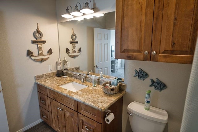 half bath with vanity, toilet, and baseboards