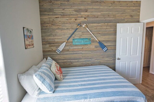 bedroom featuring wooden walls