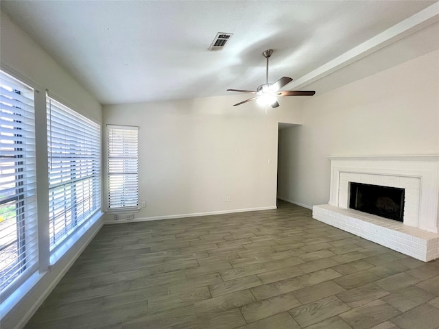 unfurnished living room featuring visible vents, a ceiling fan, dark wood finished floors, baseboards, and lofted ceiling