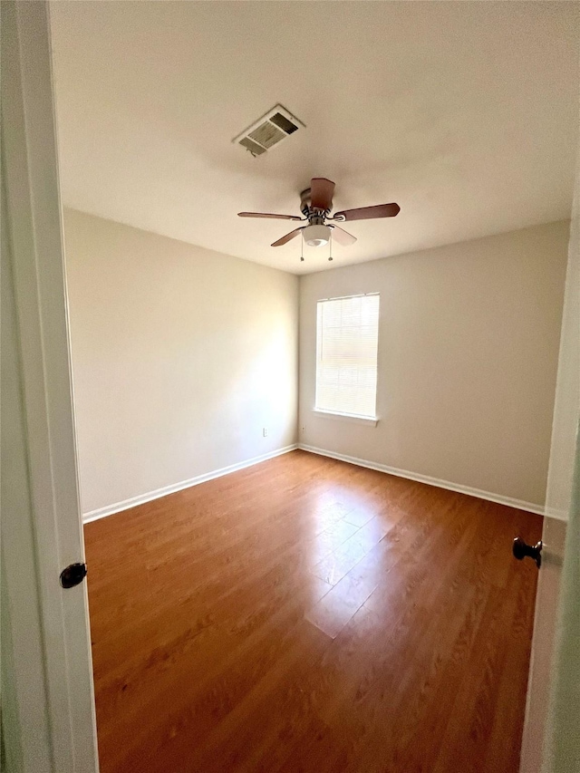 unfurnished room with visible vents, baseboards, ceiling fan, and wood finished floors