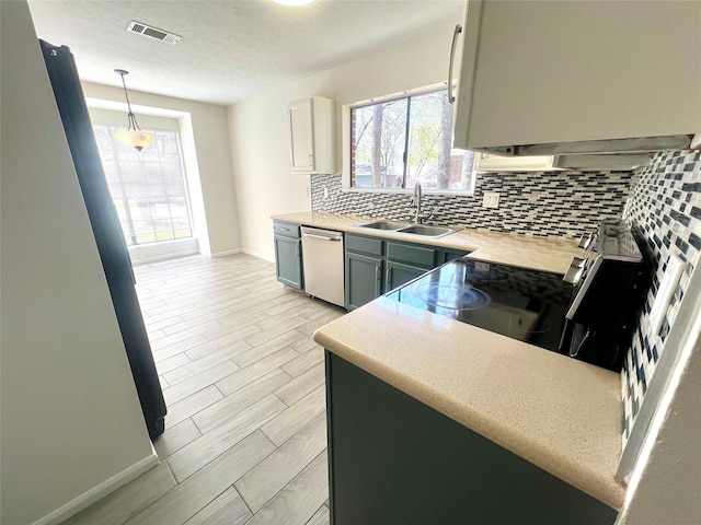 kitchen featuring visible vents, a sink, decorative backsplash, light countertops, and appliances with stainless steel finishes