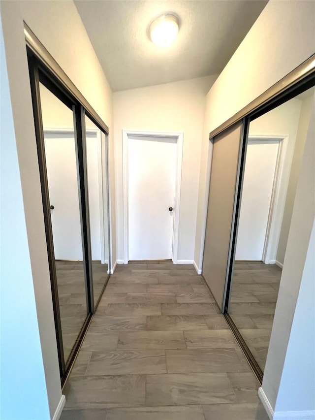 hall with light wood-type flooring and baseboards