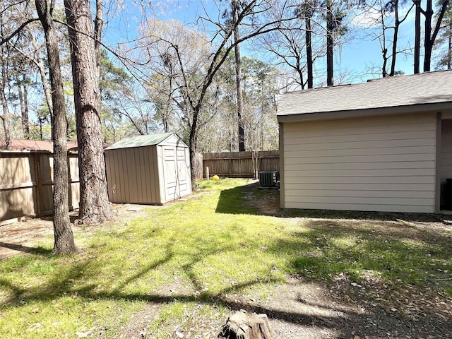 view of yard featuring a fenced backyard, a shed, cooling unit, and an outdoor structure