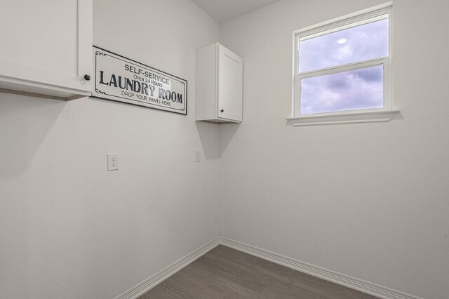 washroom with baseboards and dark wood-style flooring