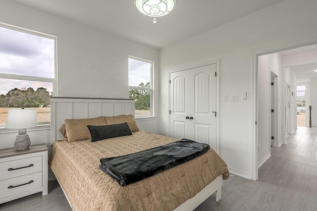 bedroom with a closet, baseboards, and wood finished floors