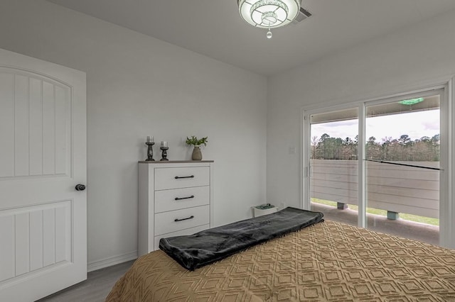 bedroom featuring access to exterior, baseboards, and wood finished floors