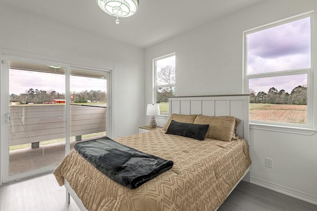 bedroom featuring baseboards, access to exterior, and light wood finished floors