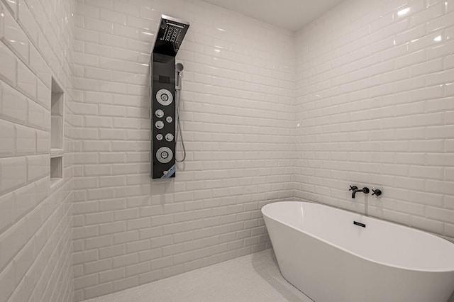 full bath featuring tile patterned floors and a freestanding bath