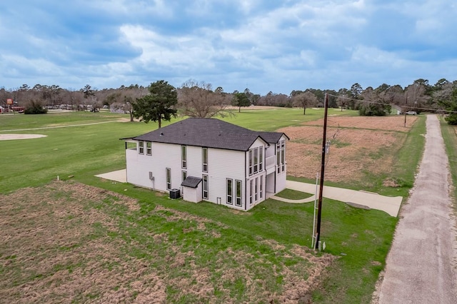 view of property exterior with cooling unit, a lawn, and a shingled roof