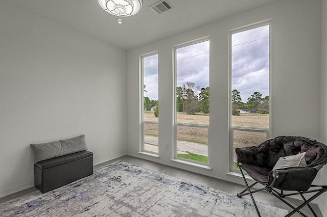 sitting room featuring visible vents, baseboards, and wood finished floors