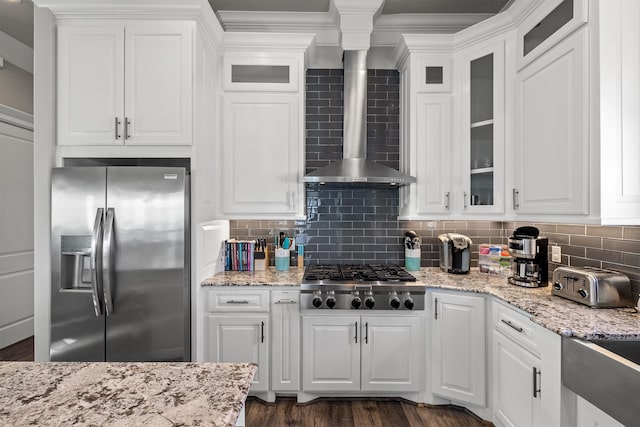 kitchen with white cabinetry, backsplash, wall chimney exhaust hood, and appliances with stainless steel finishes