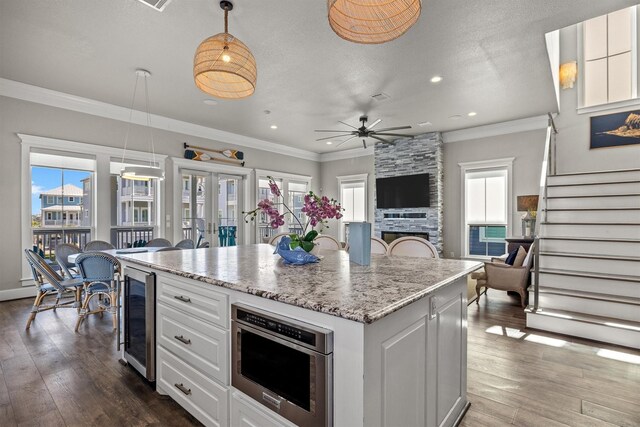 kitchen featuring beverage cooler, dark wood finished floors, and ornamental molding