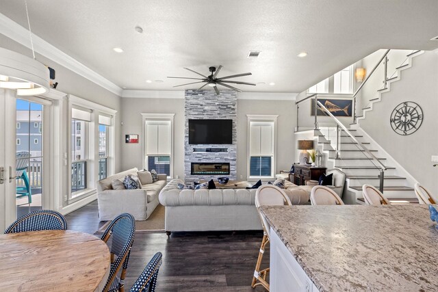 living room featuring stairs, crown molding, dark wood finished floors, and ceiling fan