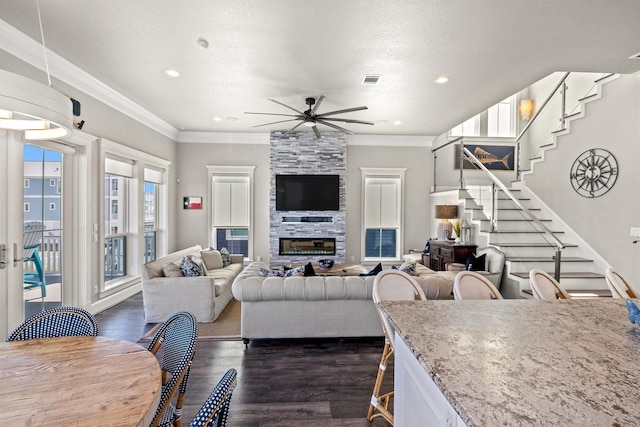 living area featuring stairs, a ceiling fan, dark wood finished floors, and crown molding