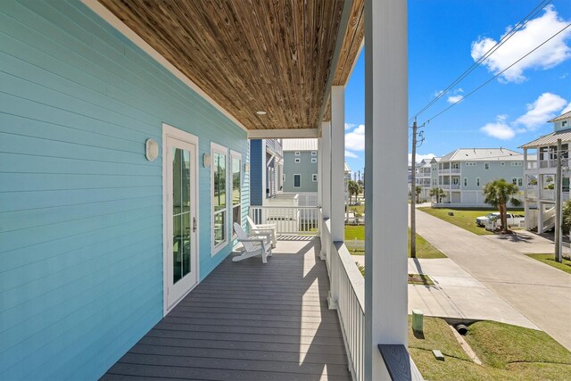 wooden terrace featuring a residential view and a porch