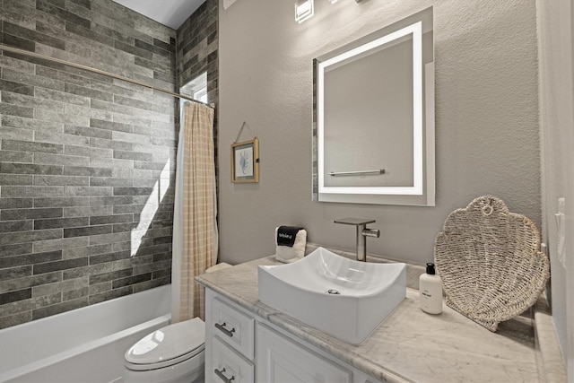 full bath featuring shower / tub combo, toilet, vanity, and a textured wall