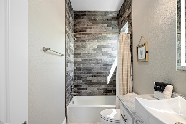 bathroom featuring toilet, shower / bath combo, vanity, and a textured wall