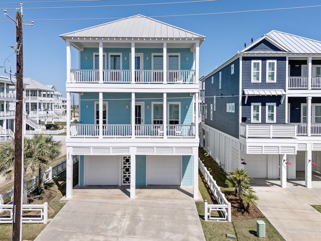 raised beach house with a standing seam roof, driveway, metal roof, and a garage