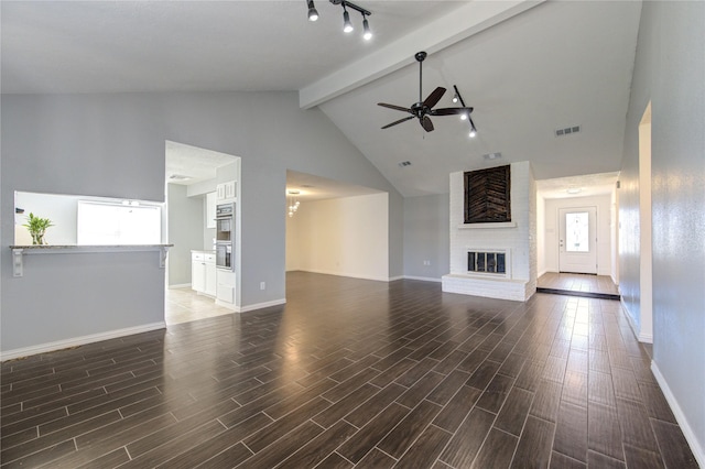 unfurnished living room featuring ceiling fan with notable chandelier, a fireplace, visible vents, and wood tiled floor